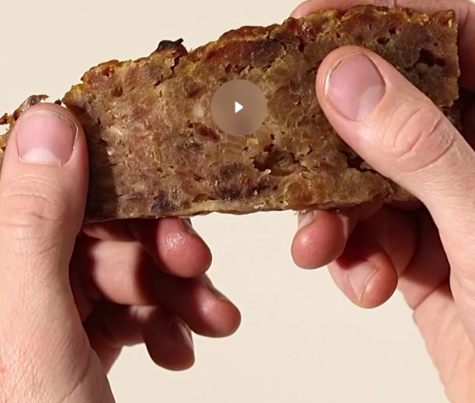 Hands breaking a Pork & Apple treat