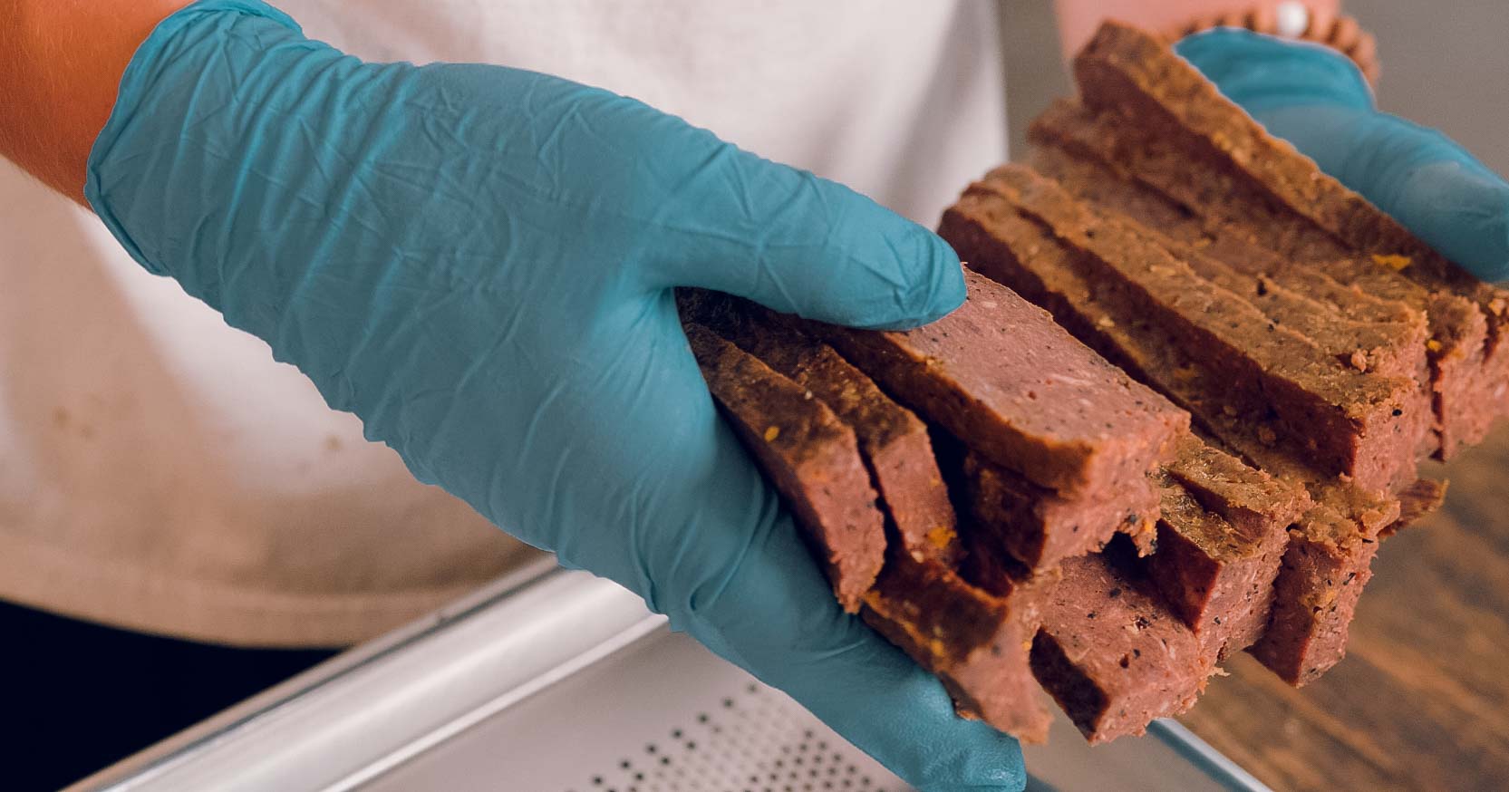 Fresh baked dog treats being sliced by hand